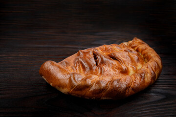 Homemade pie lies on a wooden surface.