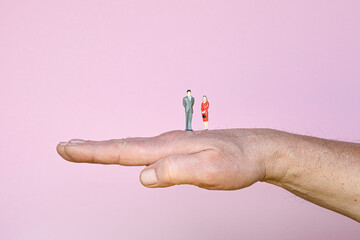 the figurines  couple of a woman and a man on the back of the hand - Powered by Adobe