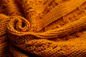 Beautiful orange knitted fabric as background, closeup