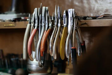Front view of a set of various tools placed on a wooden desk in a workshop
