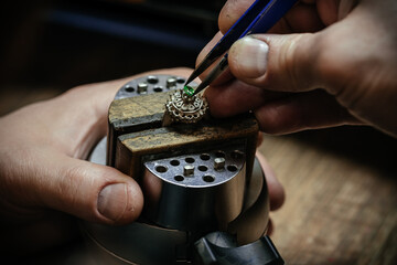 Craft jewelery making with professional tools. Ring repairing. Putting the diamond on the ring. Macro shot. A handmade jeweler process, manufacture of jewelery.