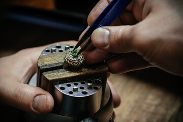 Craft jewelery making with professional tools. Ring repairing. Putting the diamond on the ring. Macro shot. A handmade jeweler process, manufacture of jewelery.