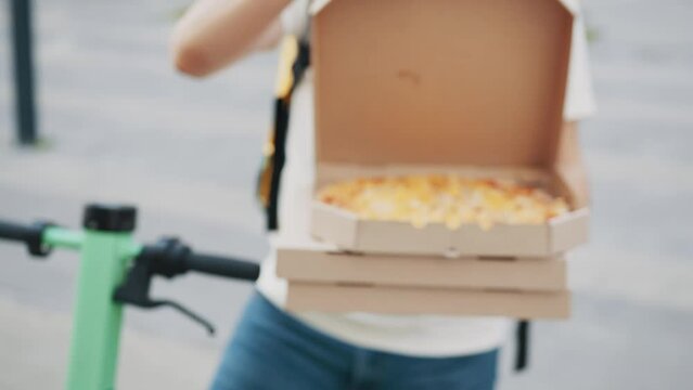 Pizza Delivery. Unrecognizable Delivery Man Wearing Medical Mask and Gloves with Pizza Box Close Up. Delivery Man stretching out a stack of pizza boxes. Delivery courier offering the pizza
