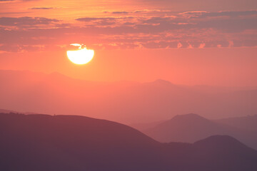 Beautiful sunset from the mountain range with orange sky in the background. 