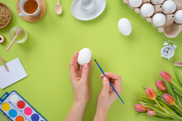 Festive Easter background. Easter eggs with flowers on a green table. Flat lay.