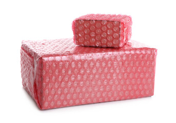 Cardboard boxes packed in red bubble wrap on white background