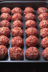 Raw meatballs on Baking trays are prepared and ready for baking in the oven. selective focus