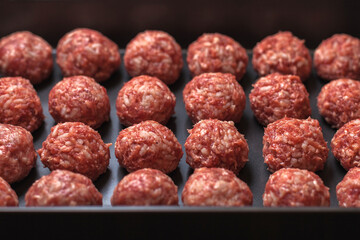 Raw meatballs on Baking trays are prepared and ready for baking in the oven. selective focus