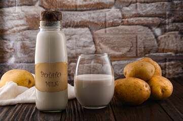 NO LOGO. NO POTATO MILK in a bottle and in a glass, Young potatoes on a plate