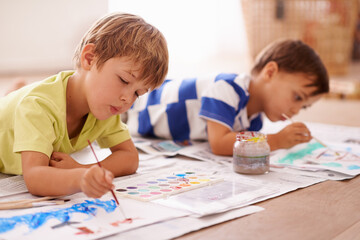 Fototapeta premium Unleashing their inner artists. Shot of two young boys painting pictures at home.