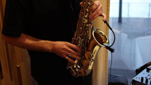 man playing golden saxophone in a restaurant