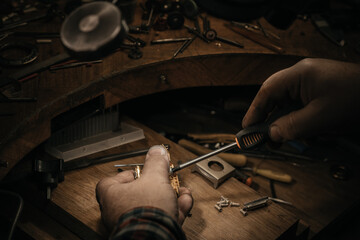 Different goldsmiths tools on the jewelry workplace. Jeweler at work in jewelry. Desktop for craft...