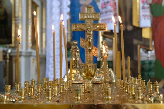 Close-up of lighted thin candles in a golden candlestick in Orthodox church 
