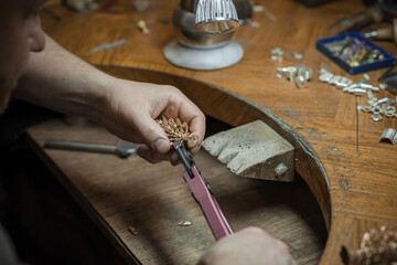 Different goldsmiths tools on the jewelry workplace. Jeweler at work in jewelry. Desktop for craft jewelry making with professional tools. Close up view of tools.