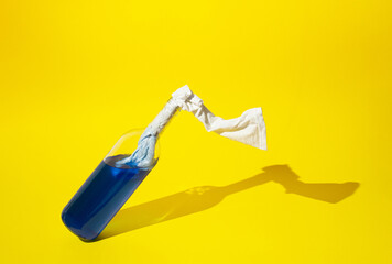 Molotov cocktail bottle full with blue liquid on yellow background. Minimal Ukraine concept.