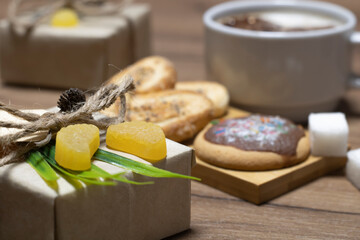 Chewing tangerine slices as a gift box decoration and a cup of coffee with biscuits