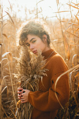 Portrait of beautiful young woman outdoor posing with soft sun light at sunset