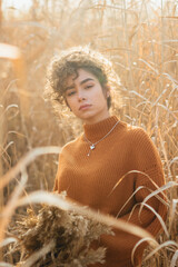 Portrait of beautiful young female model posing outdoor with soft sun light flares