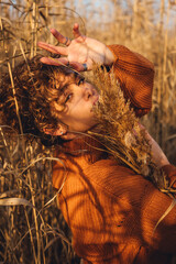 Portrait of a beautiful young woman posing outdoor with her arm over her head