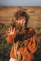 Portrait of a beautiful young woman enjoying the sun with her hand outstretched in front of her