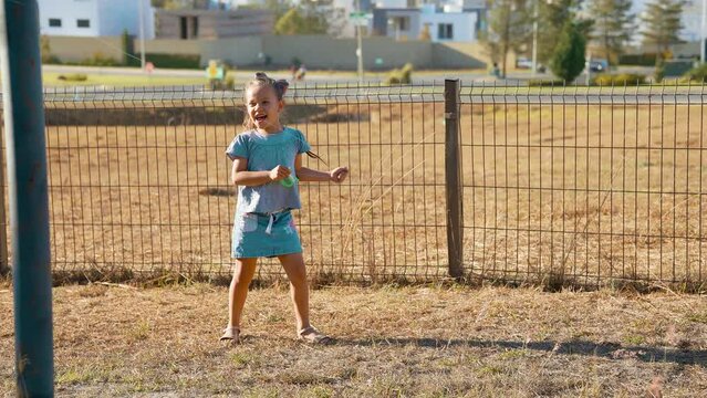 Ni&ntilde;a feliz jugando volando el papalote el cometa con el aire disfrutando en el parque al aire libre en el exterior aprendiendo conociendo el mundo