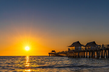 A perfect day winds down with a brilliant sunset, over the Gulf of Mexico, at the pier in Naples Florida.