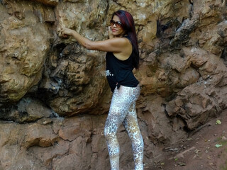 Mulher em passeio, encostada de maneira sensual em grande rocha no meio de mata localizada no parque das Mangabeiras, Belo Horizonte, Minas Gerias.