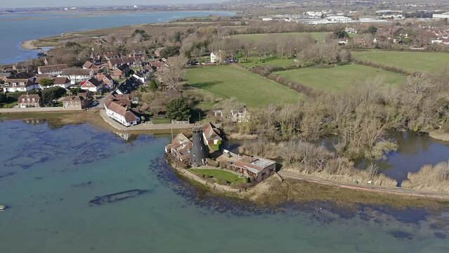 Aerial footage over Langstone Harbour and the Langstone Windmill withy the Mill Pond in the background on the waterfront of the harbour.