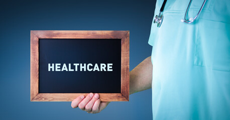 Healthcare. Doctor shows sign/board with wooden frame. Background blue