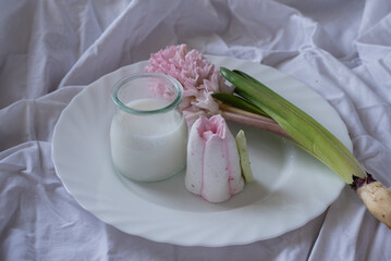 sweet marshmallow and hyacinth on a plate with a glass of milk