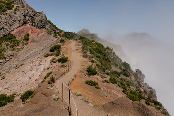 Wild nature of mountains under low clouds. Path among the mountains. Deep fog on the mountains. Wild mountains covered with clouds. Wonderful nature