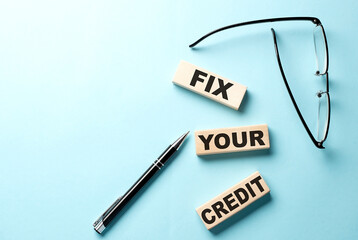 FIX YOUR CREDIT text on the wooden block ,blue background