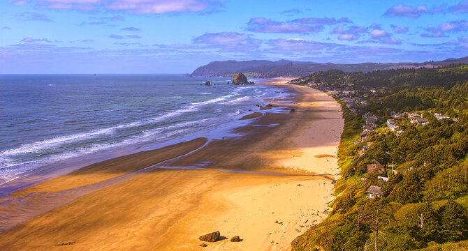 Sunny afternoon aerial south of Haystack Rock south of Canon Beach Oregon, sandy beaches, variable clouds creating unique lighter and dark areas on the sands and the pacific ocean-color graded
