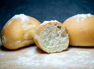 Bakery products. Table in the bakery. White bun on a cutting board. Products from wheat flour of the highest grade. Sliced ​​bun.