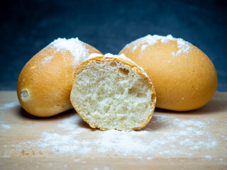 Bakery products. Table in the bakery. White bun on a cutting board. Products from wheat flour of the highest grade. Sliced ​​bun.