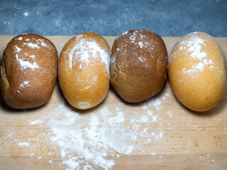 Bakery products.  Buns on a cutting board. Rye and wheat buns. Products from premium wheat flour and rye flour.