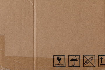 Worn cardboard texture with clear tape and safety symbols