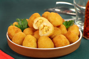 Traditional Brazilian fried snack made with chicken called Coxinha with one cut