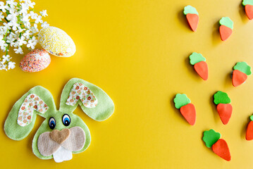 Easter decorated background, cloth eggs and easter bunny on yellow background.