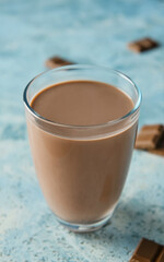 Glass of delicious chocolate milk on color background