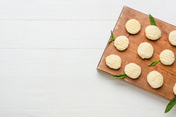 Fototapeta na wymiar Board with raw lazy dumplings on light wooden background