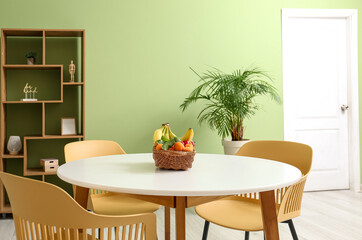 Dining table with wicker fruit basket in light room