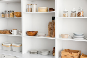 Shelf unit with clean dishware in kitchen