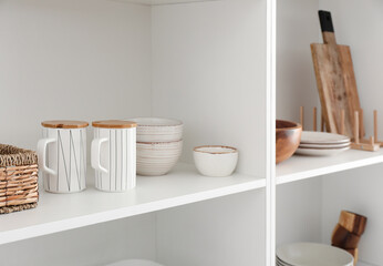 Shelf unit with clean dishware in kitchen