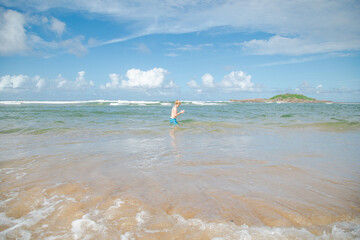 Boy swimming in crystal blue water at Park Beach in Coffs Harbour, NSW Australia
