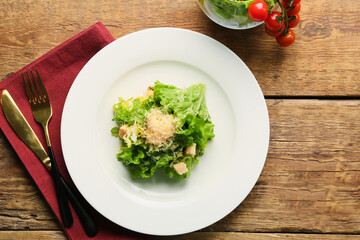 Plate with tasty vegan Caesar salad on wooden background - obrazy, fototapety, plakaty