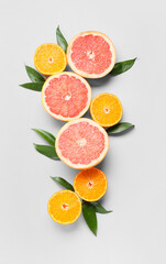 Fresh orange and grapefruit slices on light background
