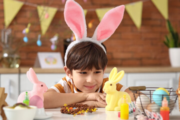 Cute little boy with bunny ears celebrating Easter at home