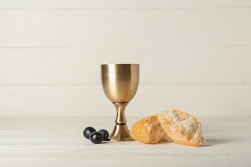 Cup of wine with bread on white wooden background