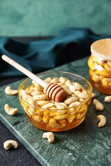Obraz na płótnie Canvas Bowl of sweet cashew nuts in honey on table